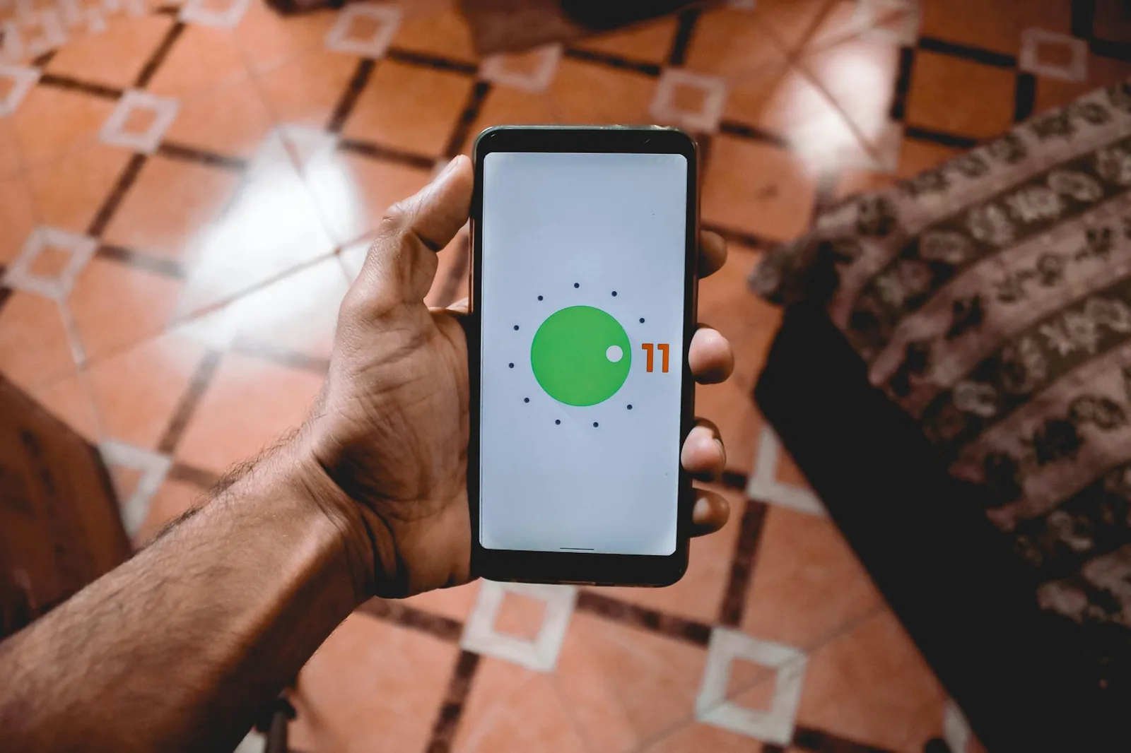Person hält Smartphone mit Systeminformationen als Hinweis auf Android-Version und Update-Prüfung