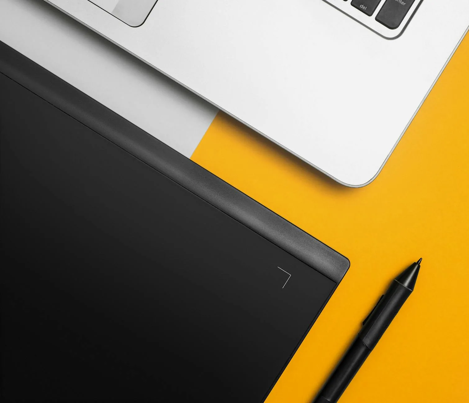 Laptop und Stift als Symbol für Layout, Planung und digitale Gestaltung