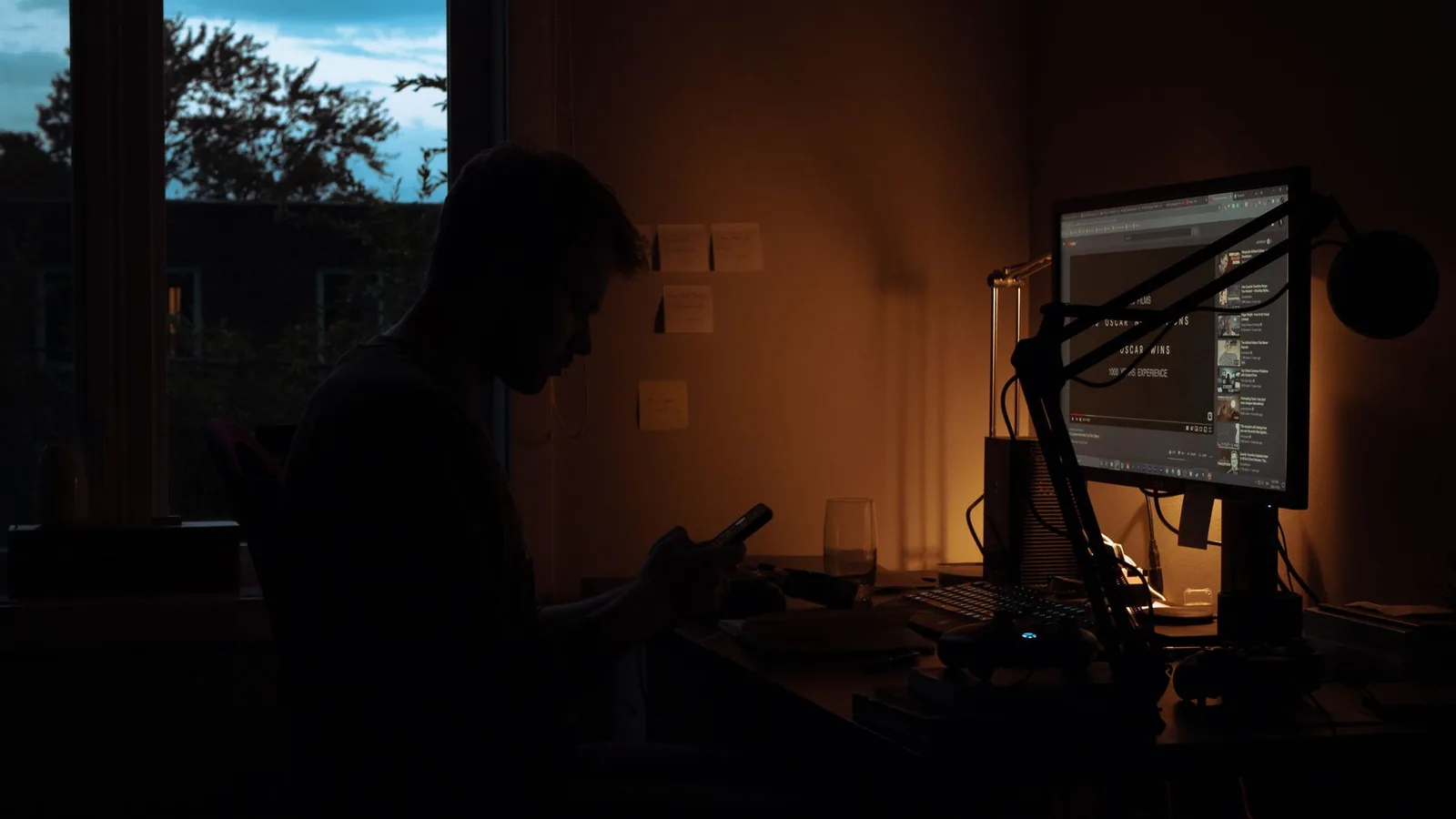 Dunkler Arbeitsplatz mit Computer als Einstieg in Dark Mode und blendarmes Arbeiten