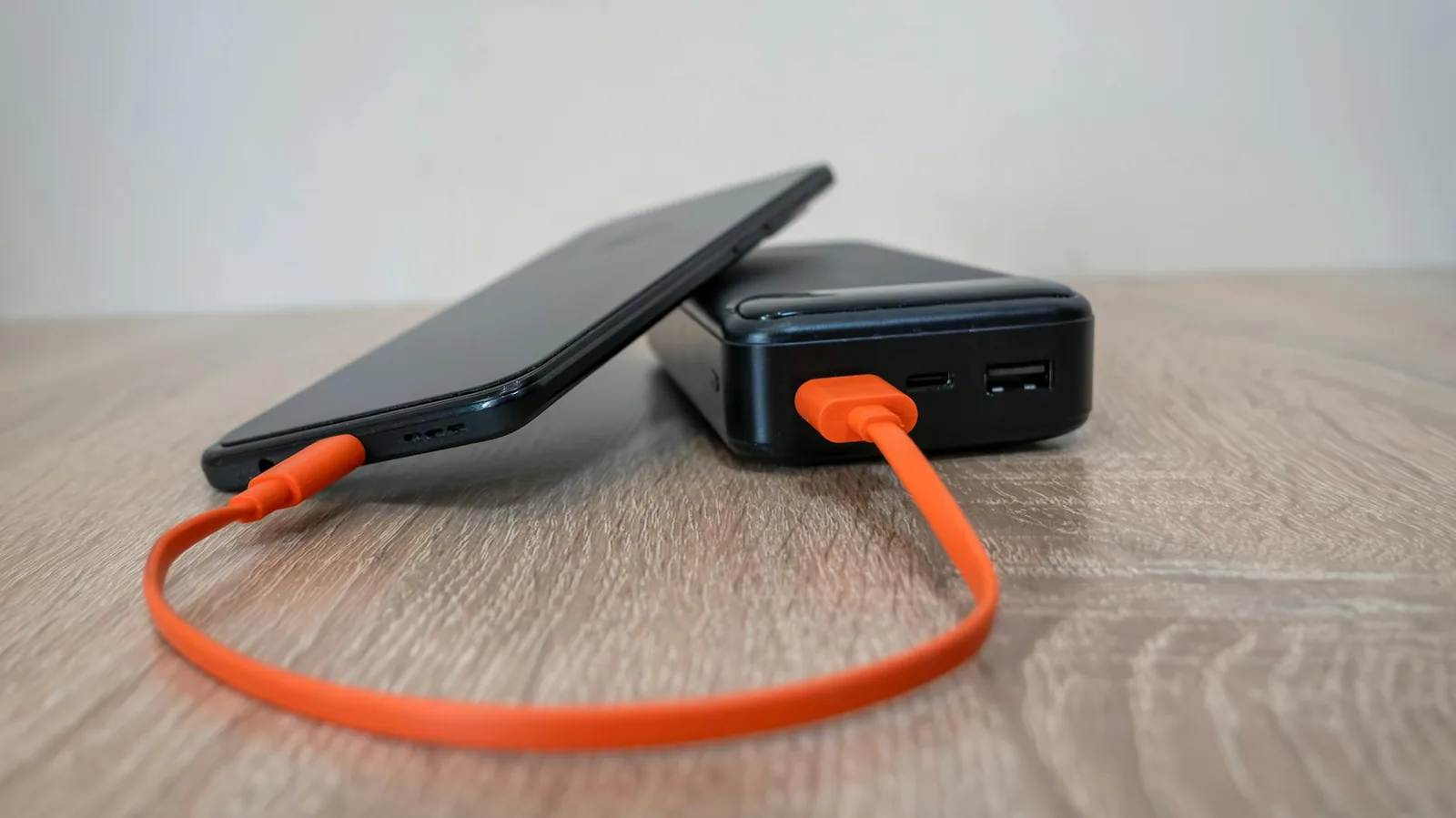 Smartphone lädt über Kabel auf einem Tisch