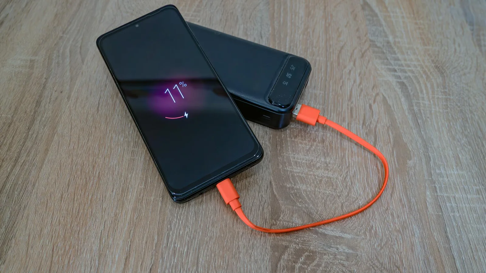 Smartphone wird mit Powerbank geladen als Symbol für Akku-Kalibrierung