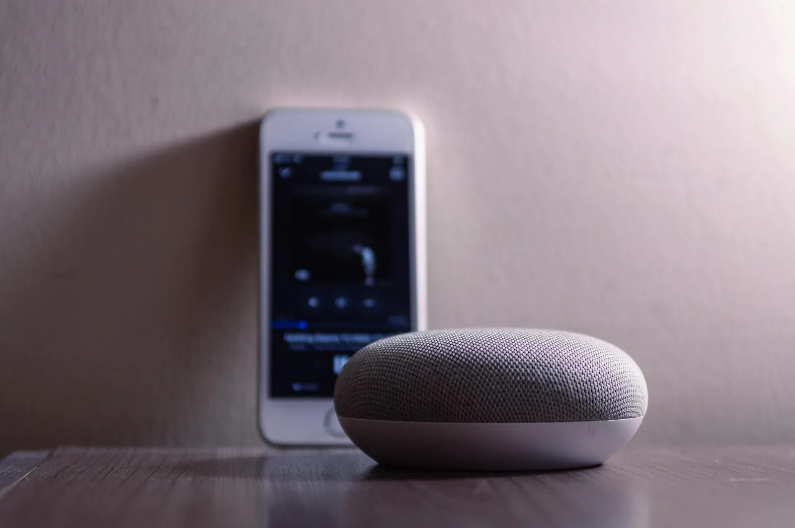 Smart Speaker neben iPhone als Beispiel für App-Steuerung im Smart Home