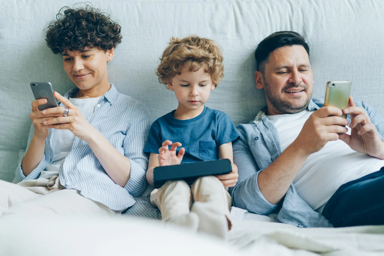 Familie mit Smartphones als Beispiel für Bildschirmzeit und gemeinsame Regeln