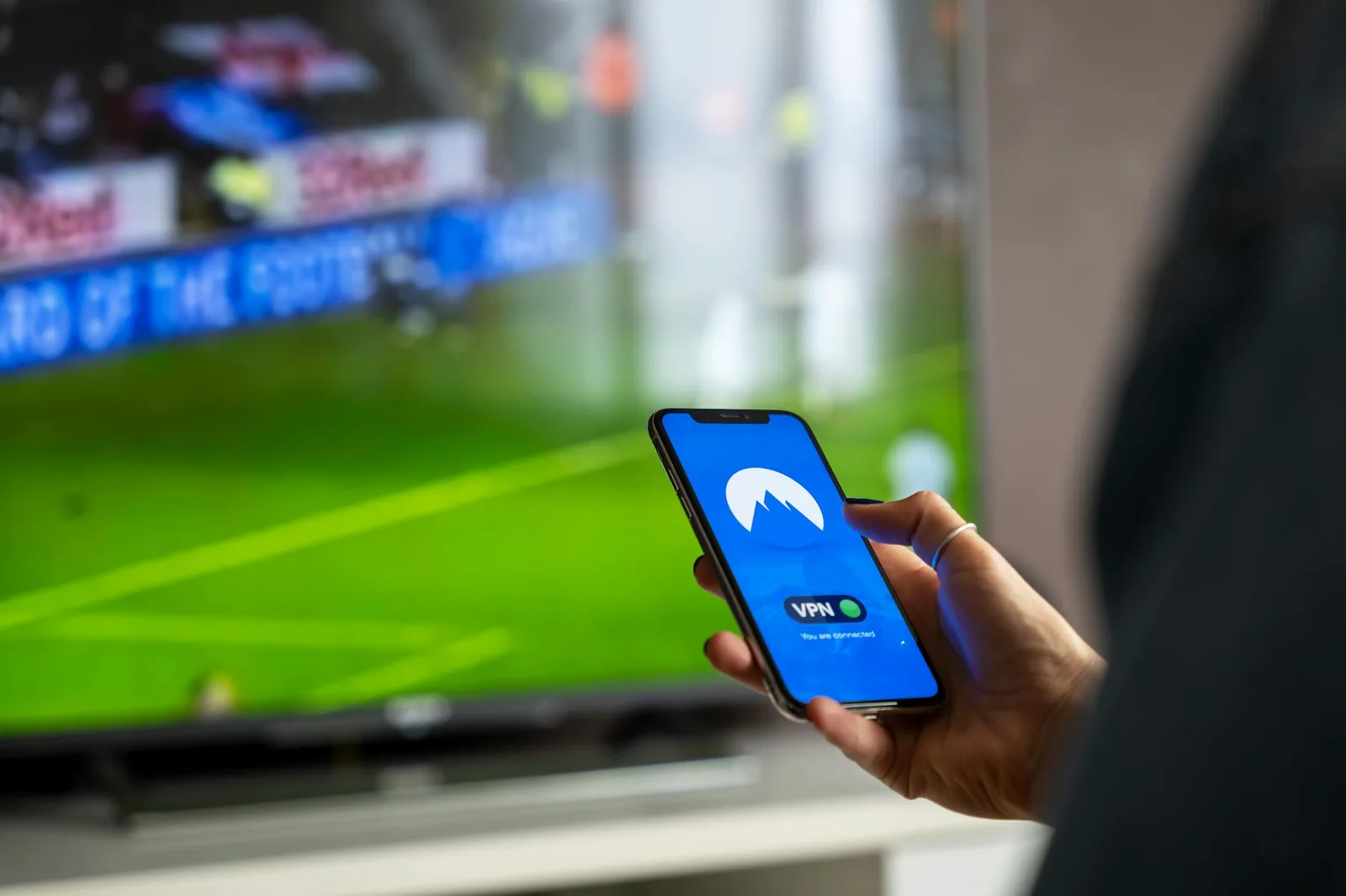 Person hält Smartphone vor digitaler Mediennutzung als Symbol für TV-Apps und IPTV-Steuerung