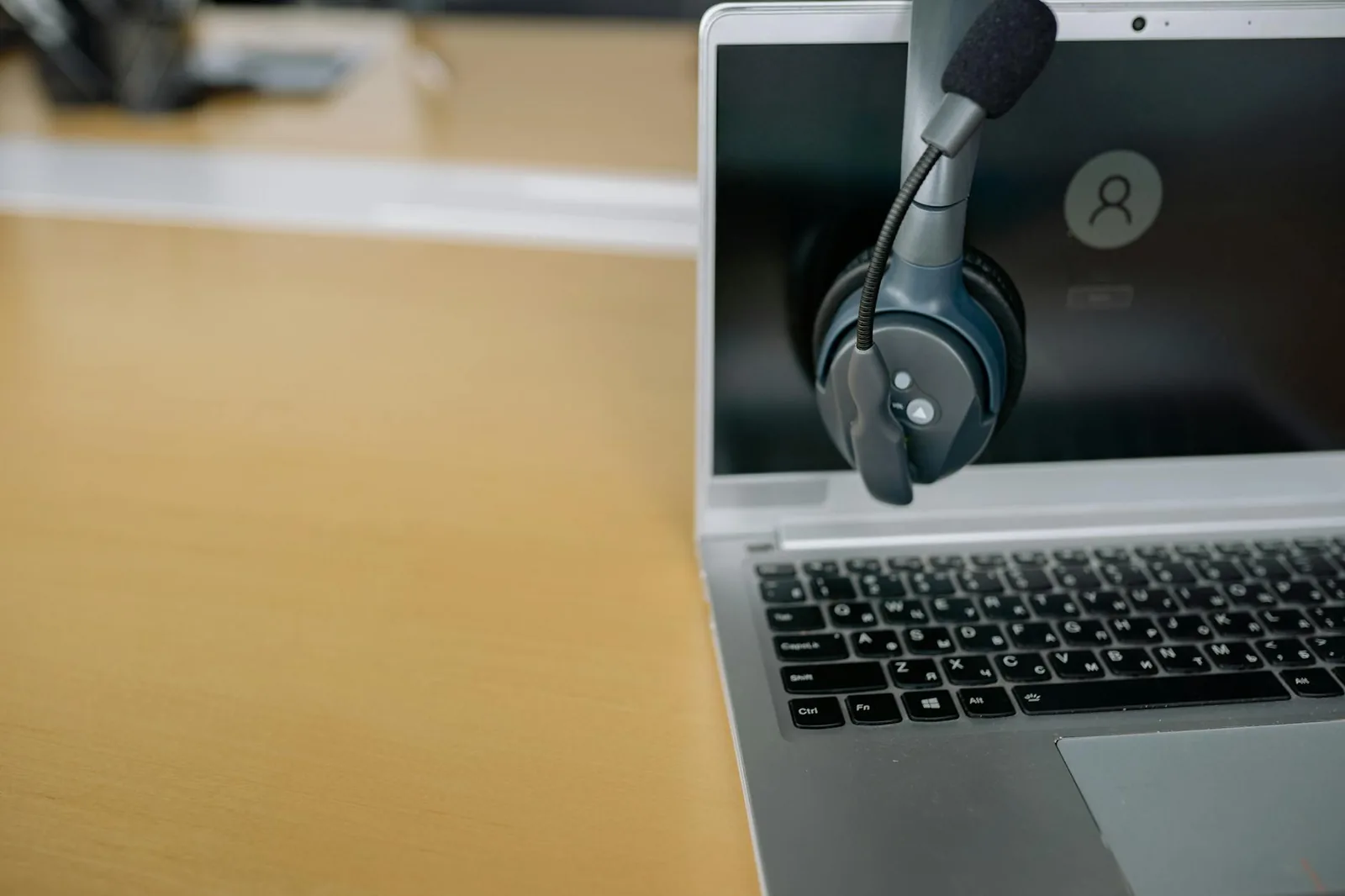 Nahaufnahme eines Headsets am Laptop als Symbol für Mikrofon-Test und Fehlersuche
