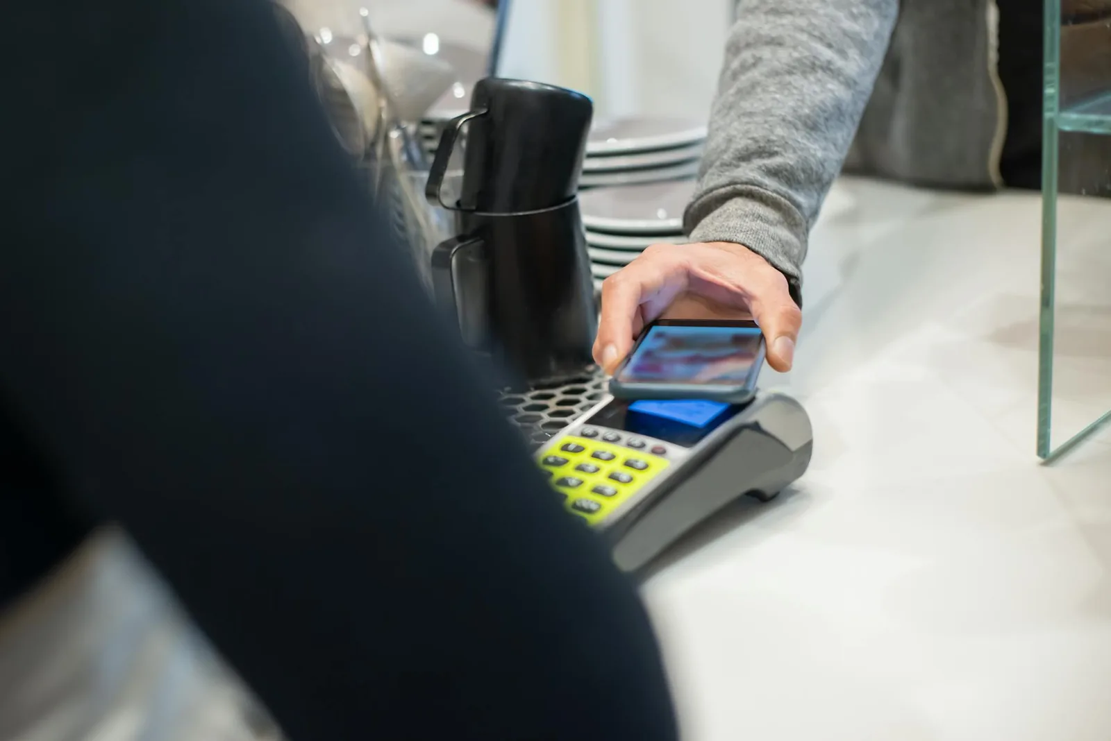 Kontaktlose Zahlung in einem Café als typische NFC-Anwendung am Smartphone