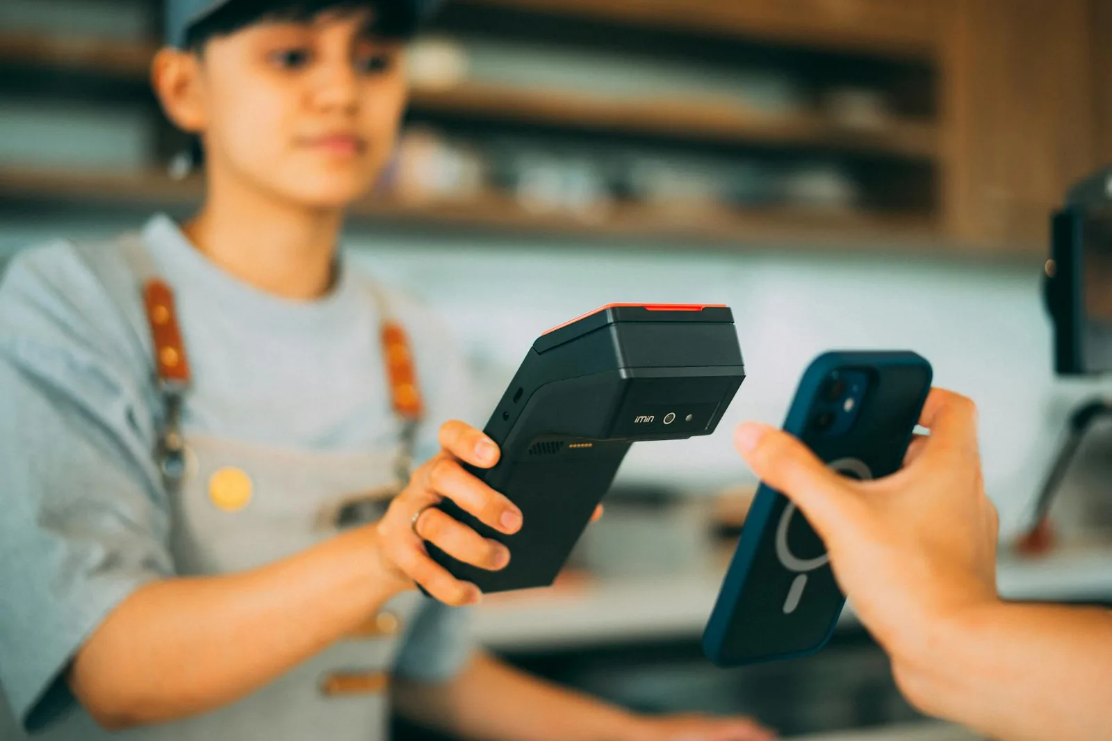 Bezahlterminal mit Smartphone als Beispiel für digitale Wallet und NFC-Zahlung
