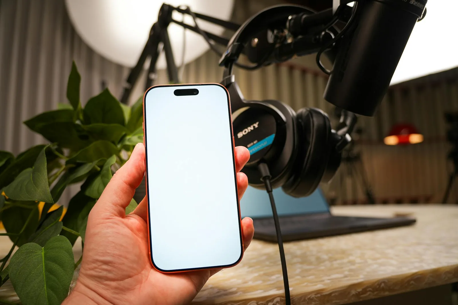 Smartphone mit Mikrofon und Kopfhörern als Einstieg in Podcast-Apps und mobiles Hören