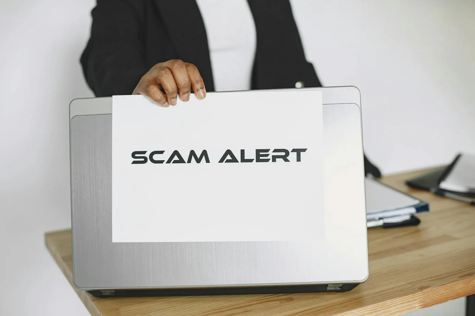Person am Laptop mit Dokumenten als Symbol für Sicherheitsvorfall und Prüfung nach Ransomware