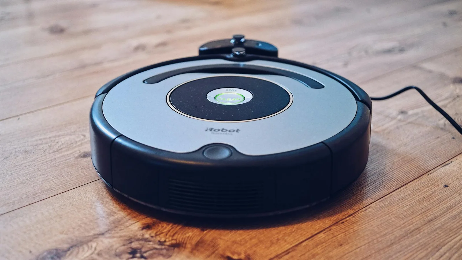 Runder Saugroboter auf Hartboden als Beispiel für automatische Bodenreinigung