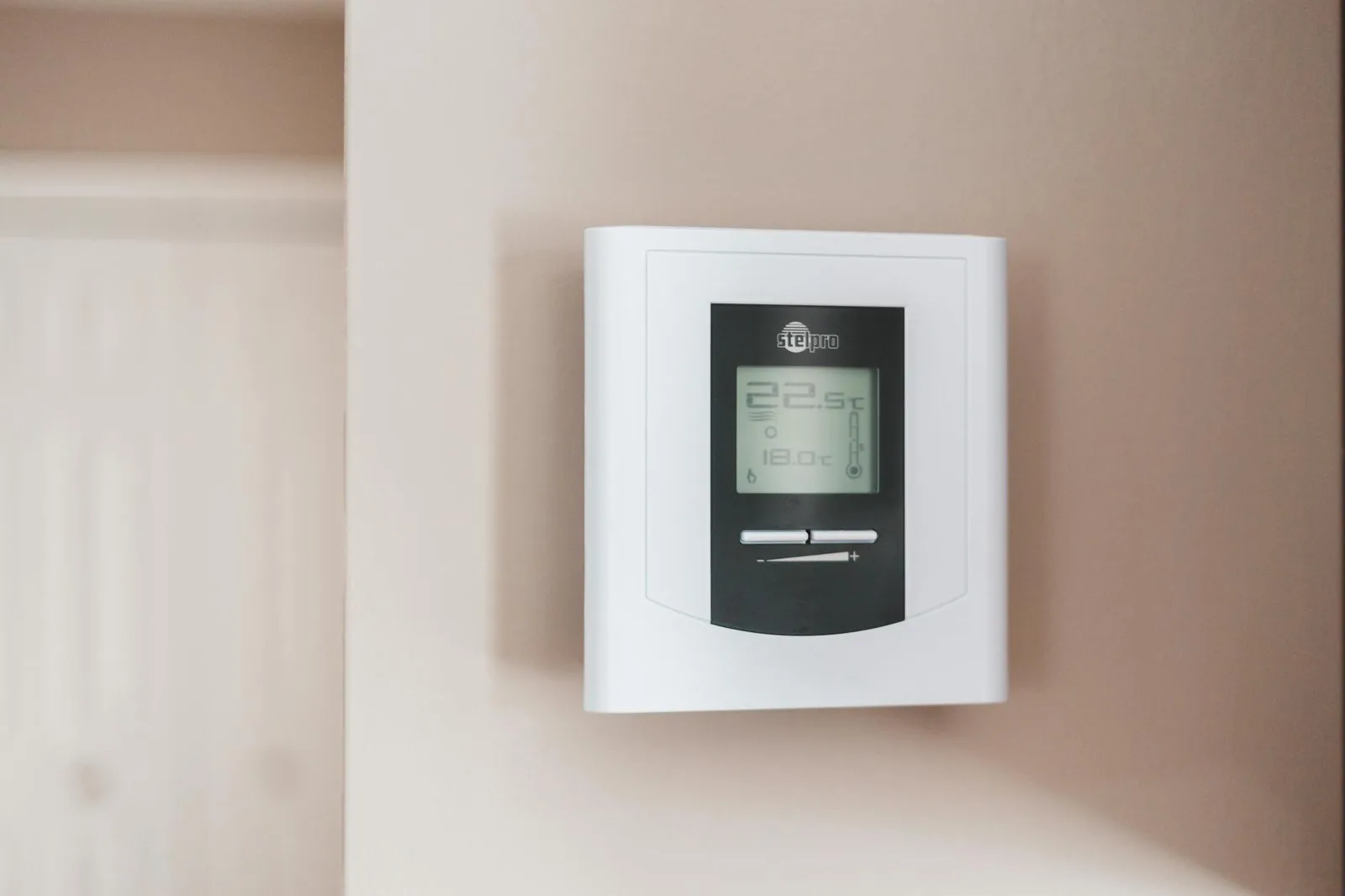 Thermostat an der Wand als Symbol für vernetzte Raumregelung und Energieeffizienz