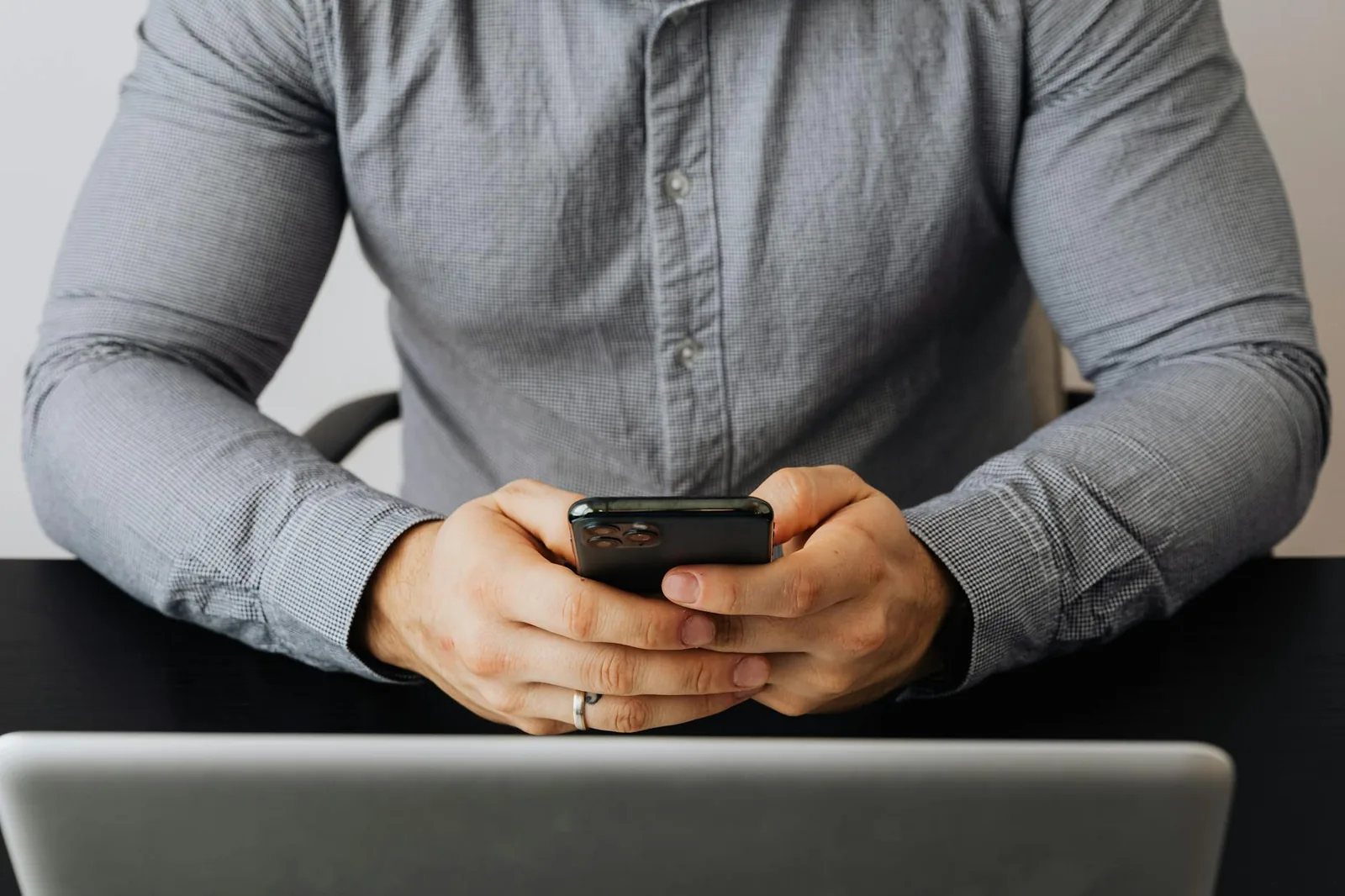 Smartphone und Laptop auf einem Schreibtisch als Symbol für WhatsApp Web am Computer